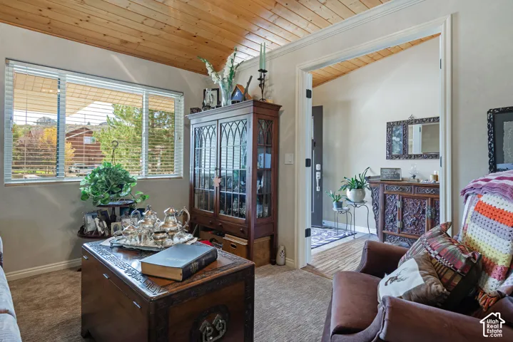 Vaulted wood-paneled ceiling, large window with horizontal blinds, and a built-in display cabinet with glass doors
