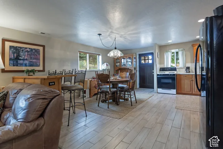 Wood-finish flooring throughout, with a built-in breakfast bar, recessed lighting, and a white oven with a black cooktop