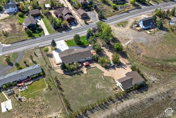 Expansive property featuring multiple structures, a paved driveway, and established landscaping