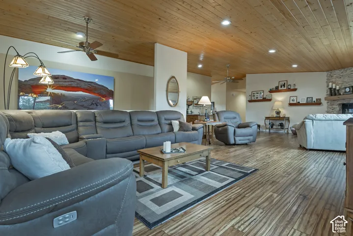 Wood-finish flooring throughout, featuring a wood-paneled ceiling with recessed lighting and ceiling fans