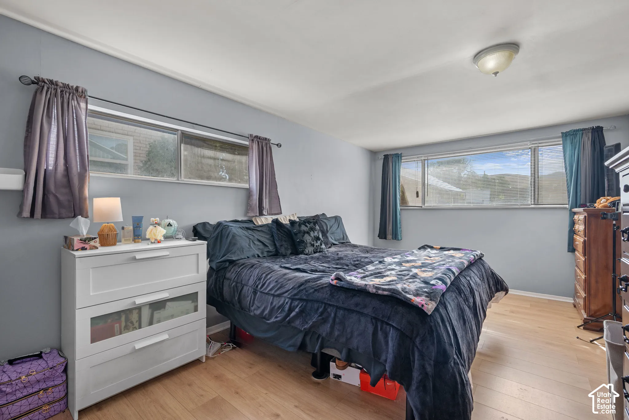 Light gray wall paint, wood-finish flooring, and multiple windows