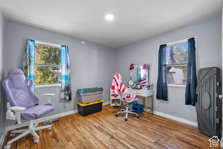 Hardwood flooring, light gray wall finishes, recessed lighting, and two windows