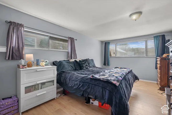 Light gray wall paint, wood-finish flooring, and multiple windows