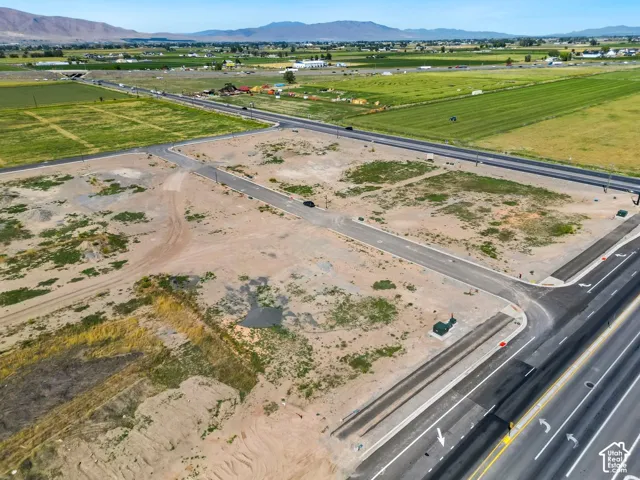 Expansive development parcels with paved road access, existing utility boxes, and mountain scenery