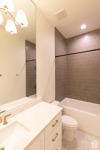White vanity with gold-tone hardware, rectangular undermount sink, and a white countertop