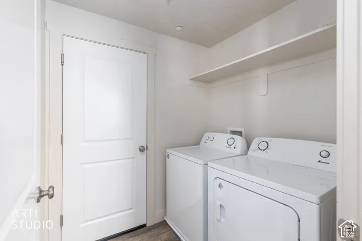 Laundry area with wood-finish flooring and a built-in storage shelf