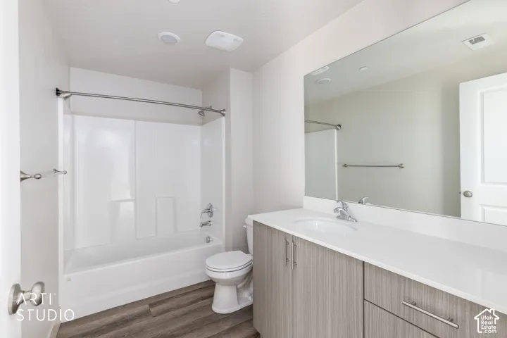 Full vanity mirror, integrated sink, and wood-finish cabinetry