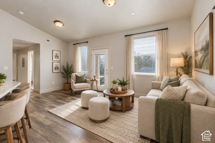 Wood-finish flooring, recessed lighting, and a white countertop bar seating area