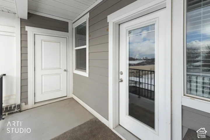 Private balcony with concrete flooring, accented by a black metal railing