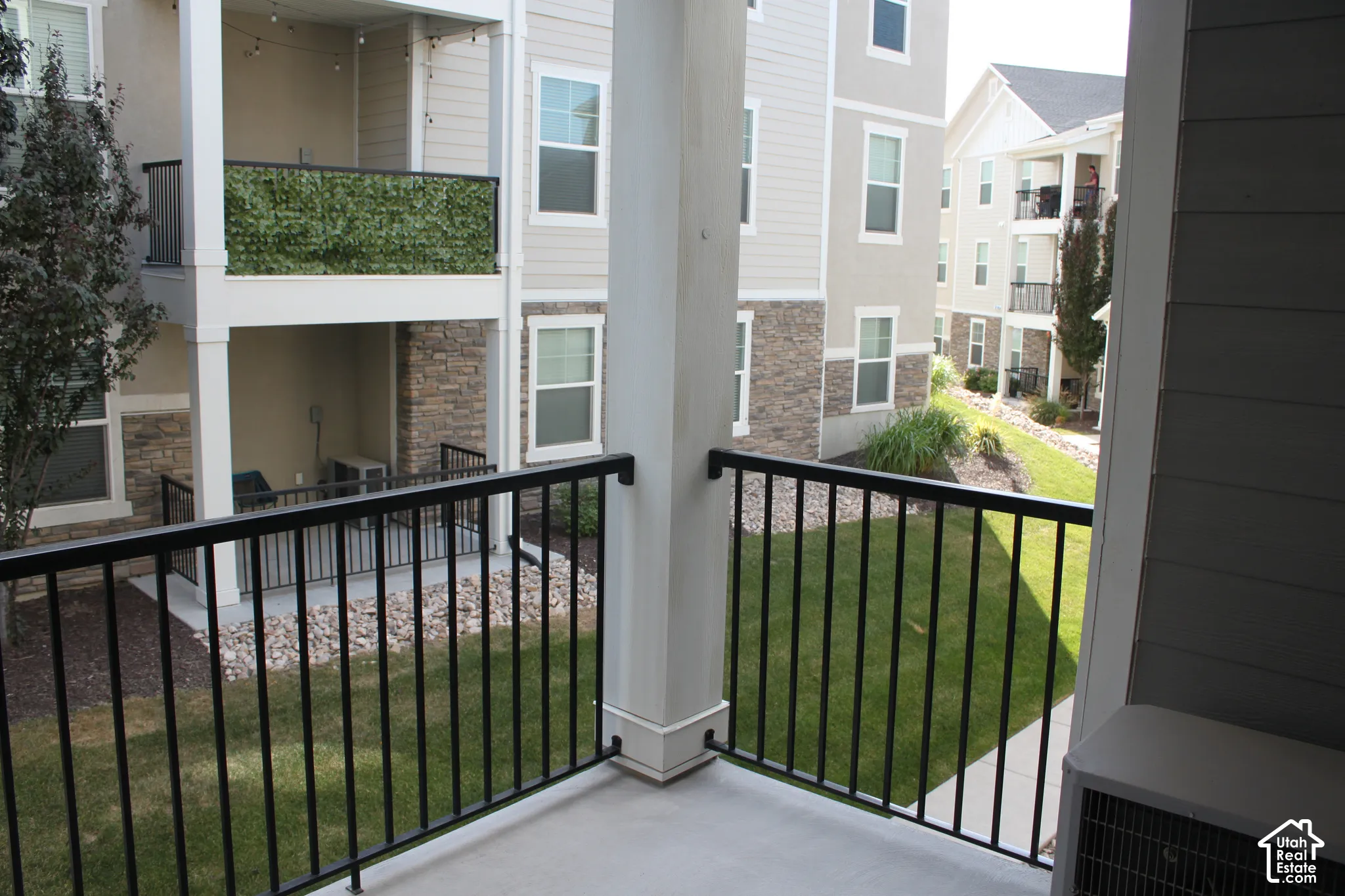 Private balcony with a concrete surface and black metal railing