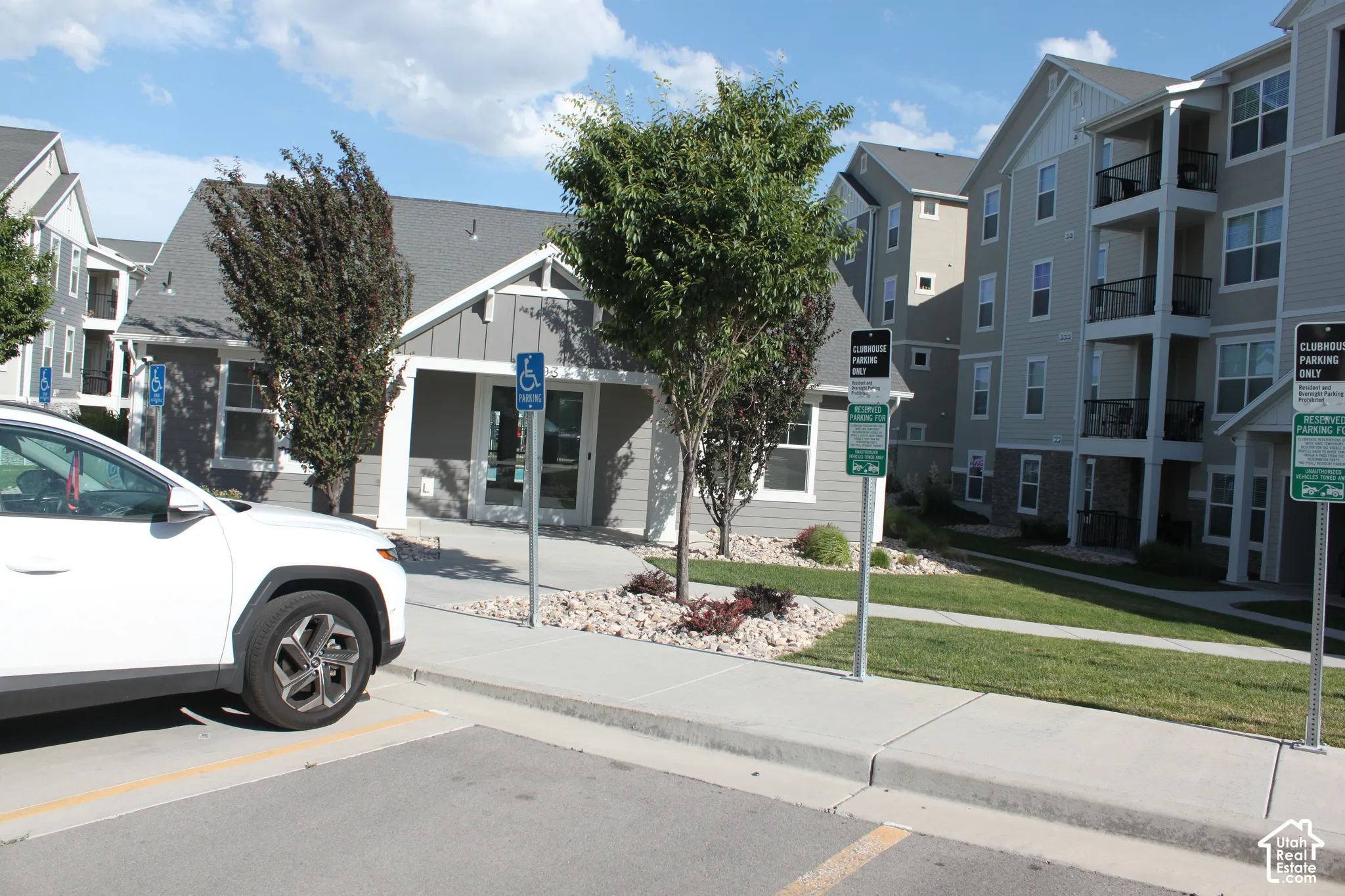 Community center/poolhouse with multi-story facades, gray siding, and a gabled roofline