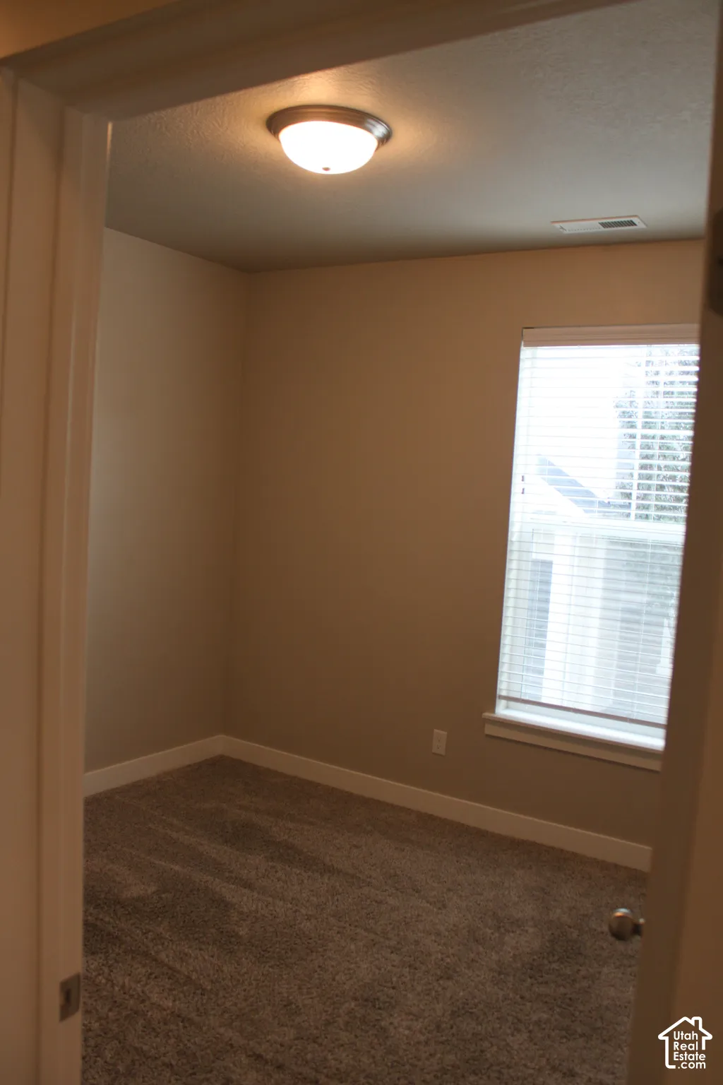 Neutral-toned walls complement the carpeted flooring in bedroom 2 with a closet
