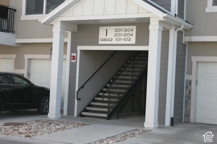 Covered entryway with white columns and dark gray siding