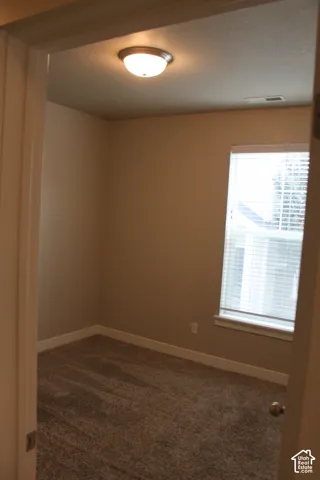 Neutral-toned walls complement the carpeted flooring in bedroom 2 with a closet