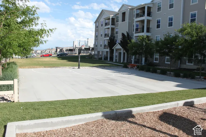 Outdoor basketball court with a paved surface and perimeter landscaping