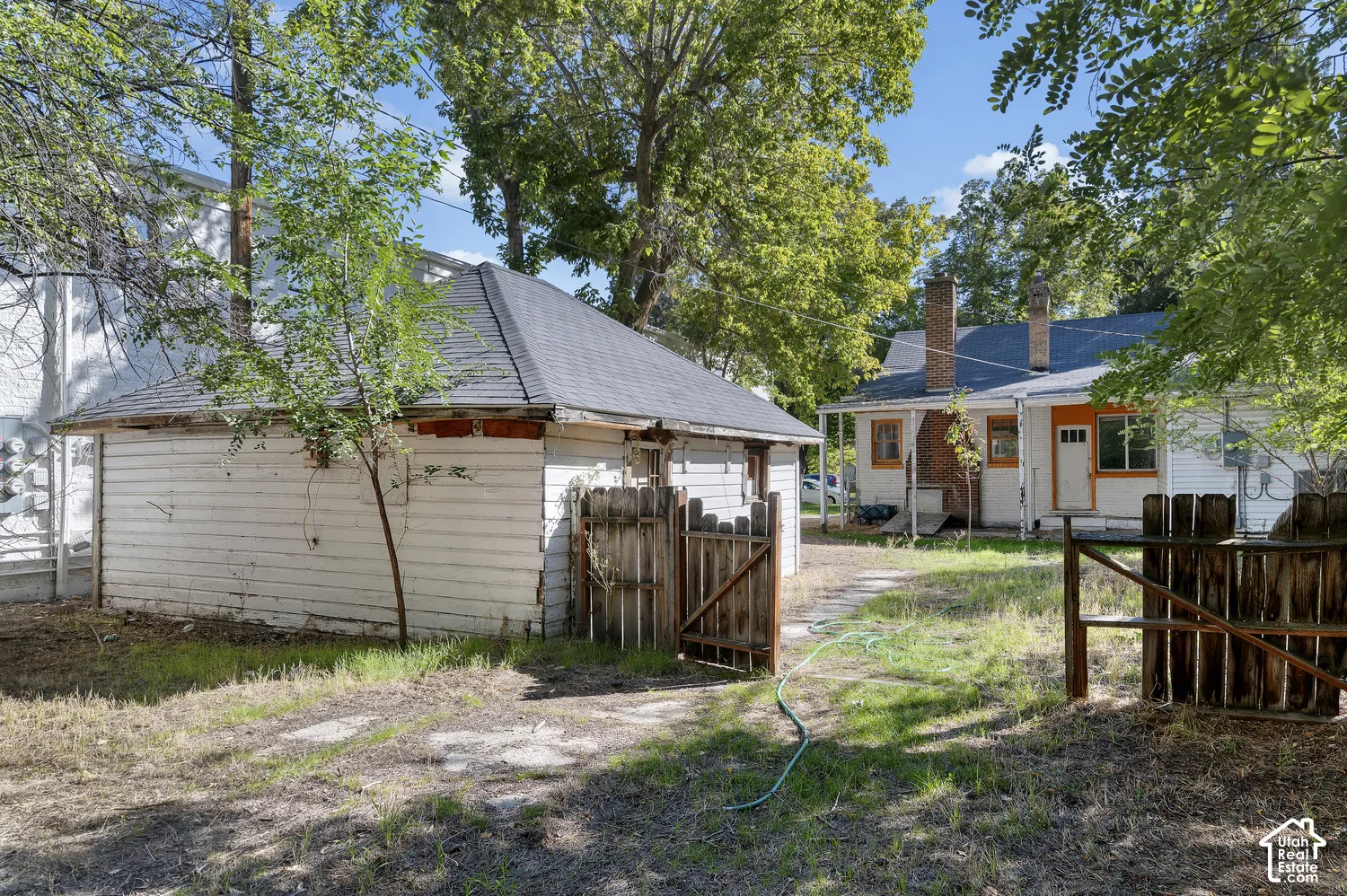 Detached garage structure with a shingled roof and wood siding