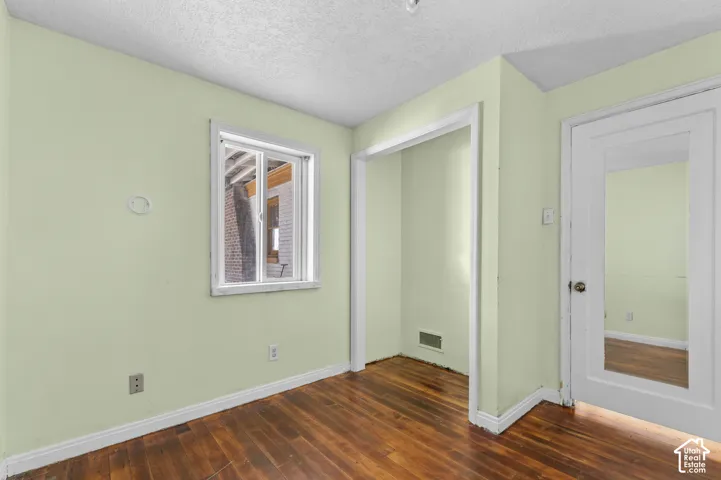 Hardwood flooring, painted walls, window with white trim, white door with glass panel