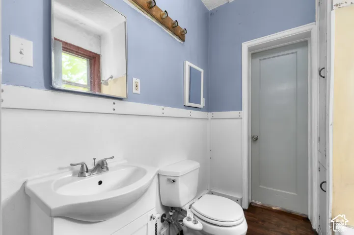 White vanity with an integrated sink and dual-handle faucet, accompanied by a toilet