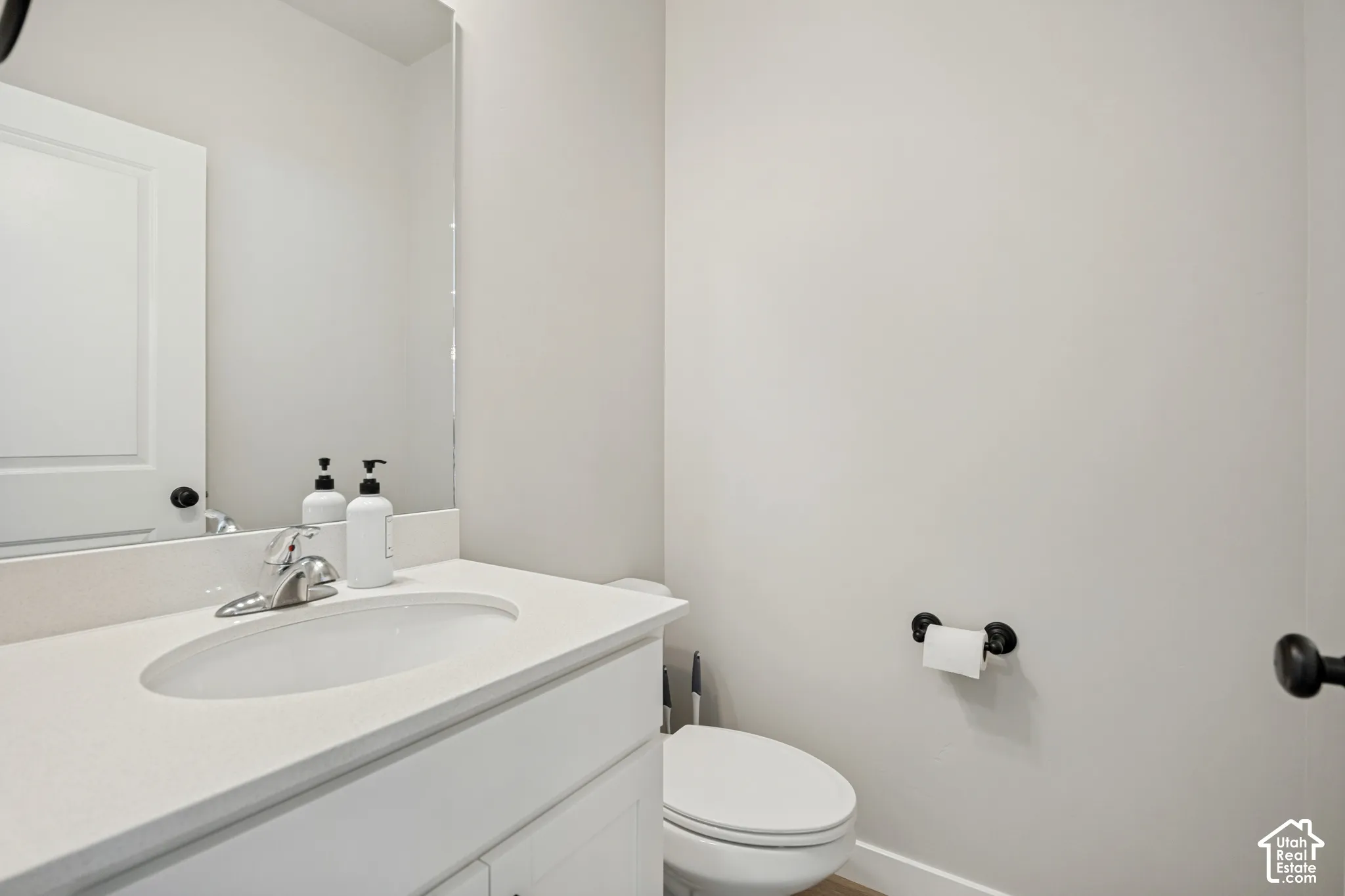 Vanity with a polished chrome faucet, under-mount sink, and light-toned countertop