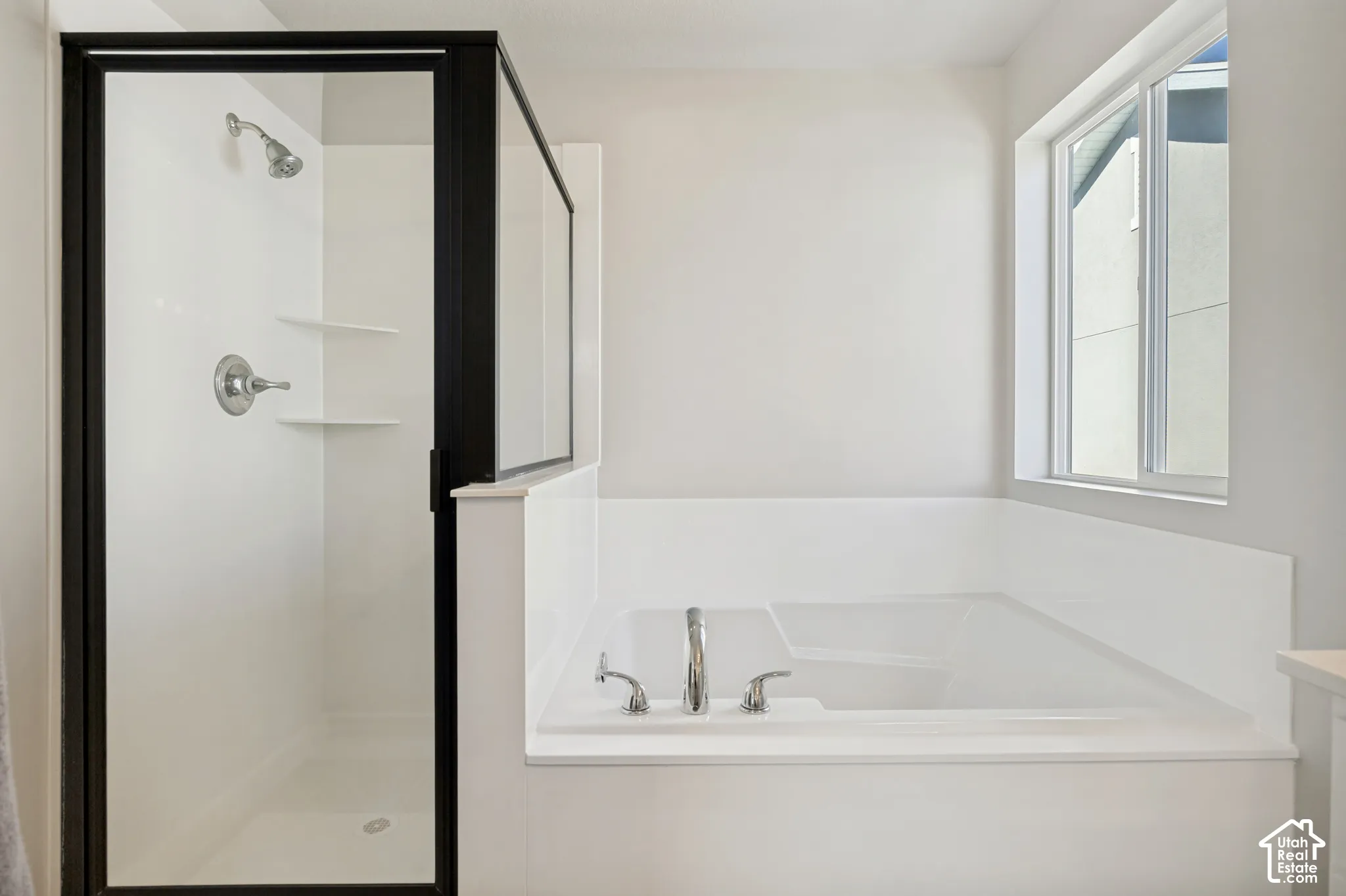 Built-in shower with a black-framed glass enclosure, built-in shelving, and a chrome shower head