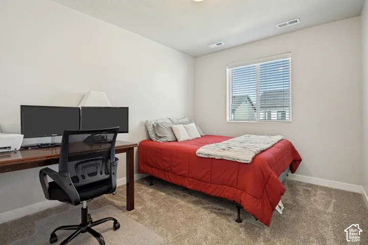 Neutral wall paint, carpeted flooring, and a single window with horizontal blinds