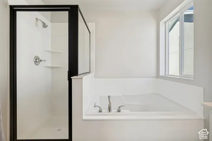 Built-in shower with a black-framed glass enclosure, built-in shelving, and a chrome shower head