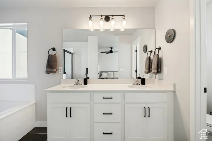 Dual vanity with white cabinetry, matte black hardware, and light-toned countertops