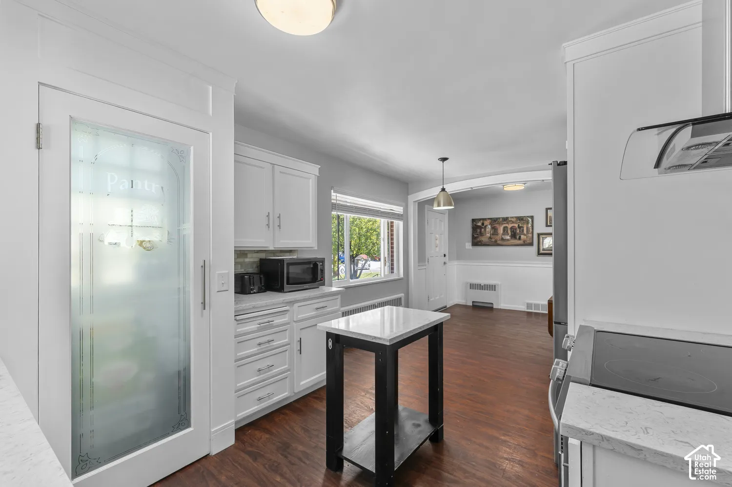 White cabinetry with brushed nickel hardware, light-toned countertops, and a subway tile backsplash