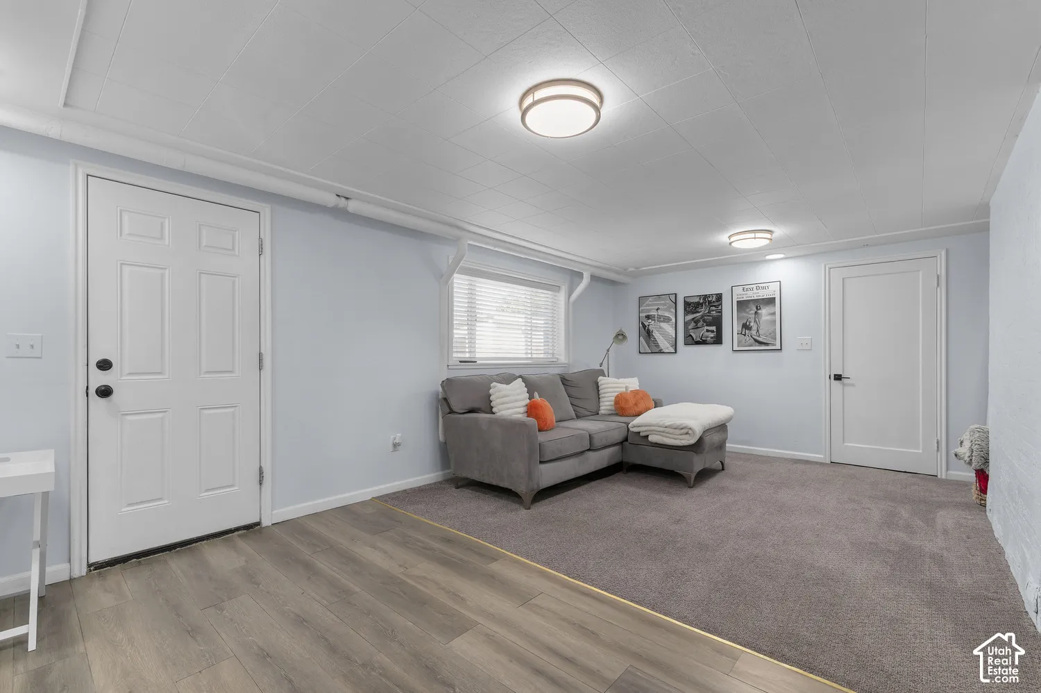 Recessed lighting, wood-finish flooring, light blue wall paint, white trim, and a window with blinds