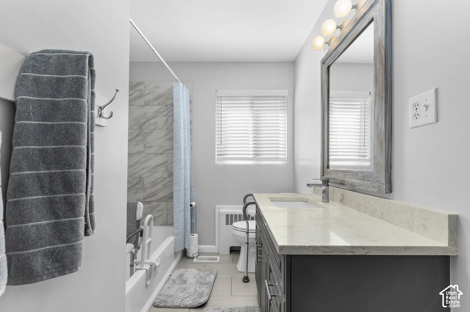 Vanity with light-toned countertop, undermount sink, and chrome faucet