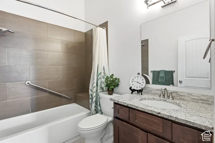 Full vanity with integrated sink, granite countertop, and mosaic tile backsplash
