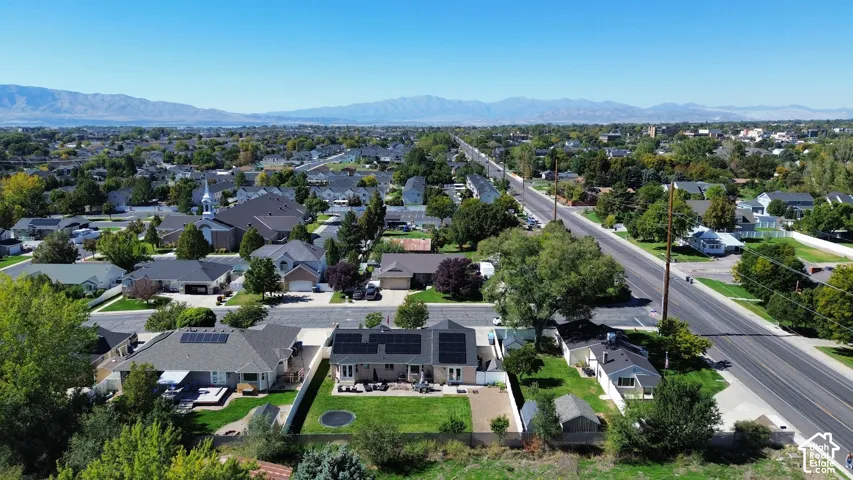 Residential neighborhood with established homes, tree-lined streets, and distant mountains