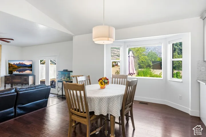 Hardwood-finish flooring throughout, a vaulted ceiling, and a bay window