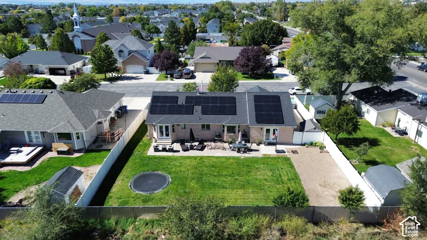 Expansive fenced backyard featuring a grassy lawn, gravel area, and two outbuildings