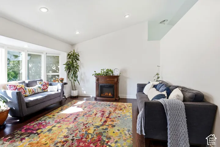 Bay window with multiple panes, recessed ceiling lighting, wood-finish flooring, and a decorative fireplace with a wood-finish mantel
