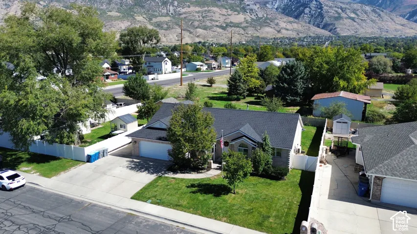 Single-family residence with an attached garage, featuring a dark shingle roof and a light-colored exterior