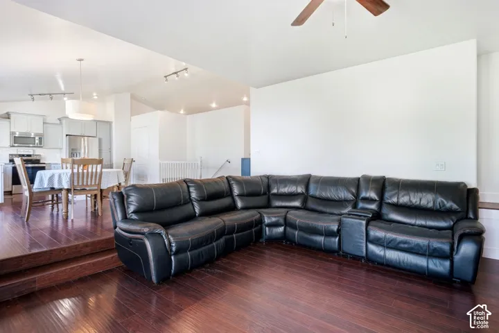 Vaulted ceilings with a ceiling fan, recessed lighting, wood-finish flooring, and a kitchen with stainless steel appliances