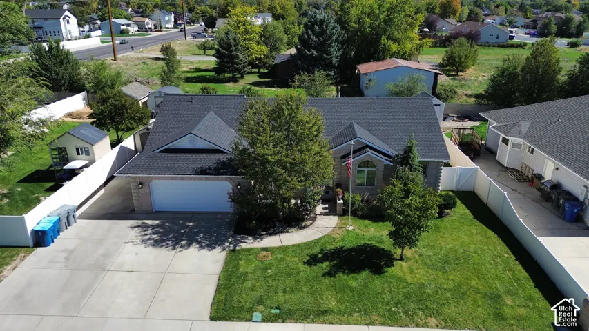 Traditional-style residence featuring a dark shingle roof, stone veneer siding, and an attached two-car garage