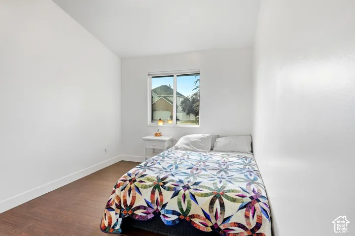Window with natural light, wood-finish flooring, white walls, and a recessed ceiling