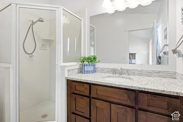 Glass-enclosed shower with a handheld showerhead