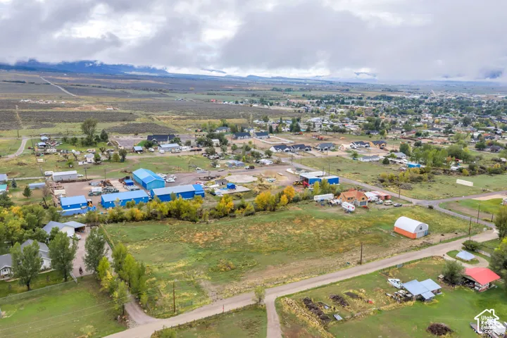 Expansive land parcels, established residential areas, commercial structures, and distant mountain scenery
