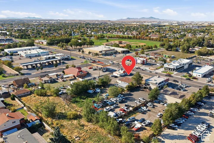 Aerial perspective showcasing commercial properties, surface parking areas, and mature trees