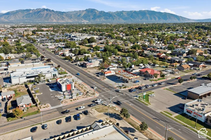 Expansive urban landscape featuring a clear mountain backdrop, multiple commercial properties, and residential buildings