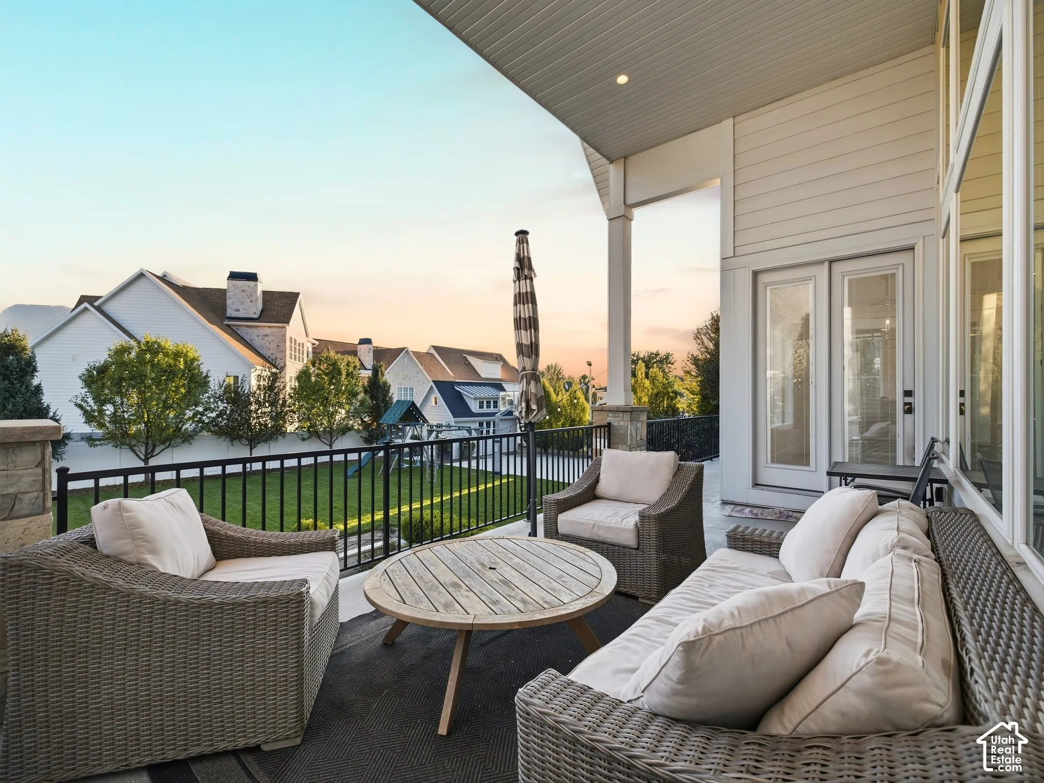Covered patio featuring a ceiling-mounted light, a stone-clad column, and a black metal railing