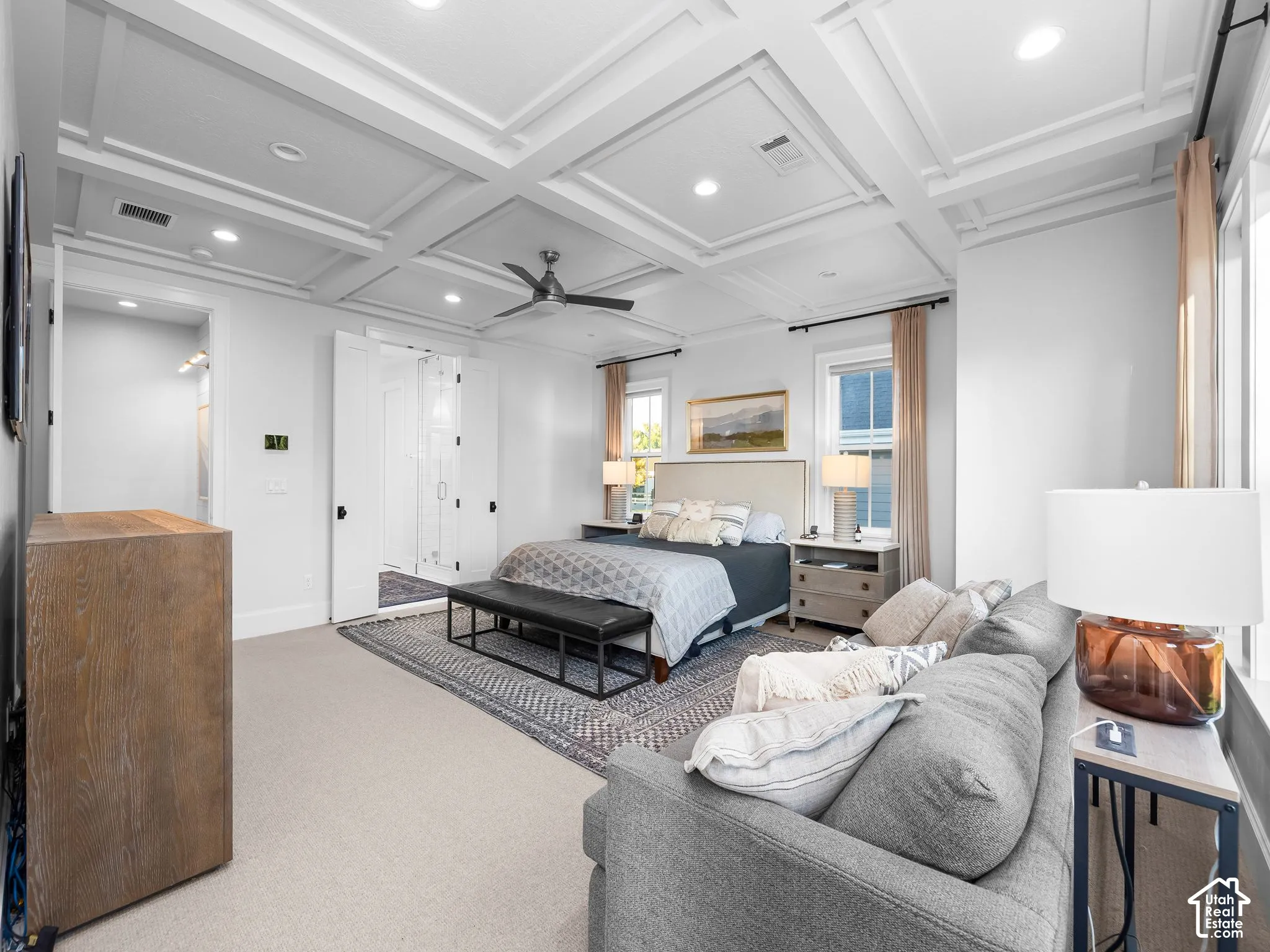 Coffered ceiling with recessed lighting and a ceiling fan, light-toned carpet flooring, and white paneled doors