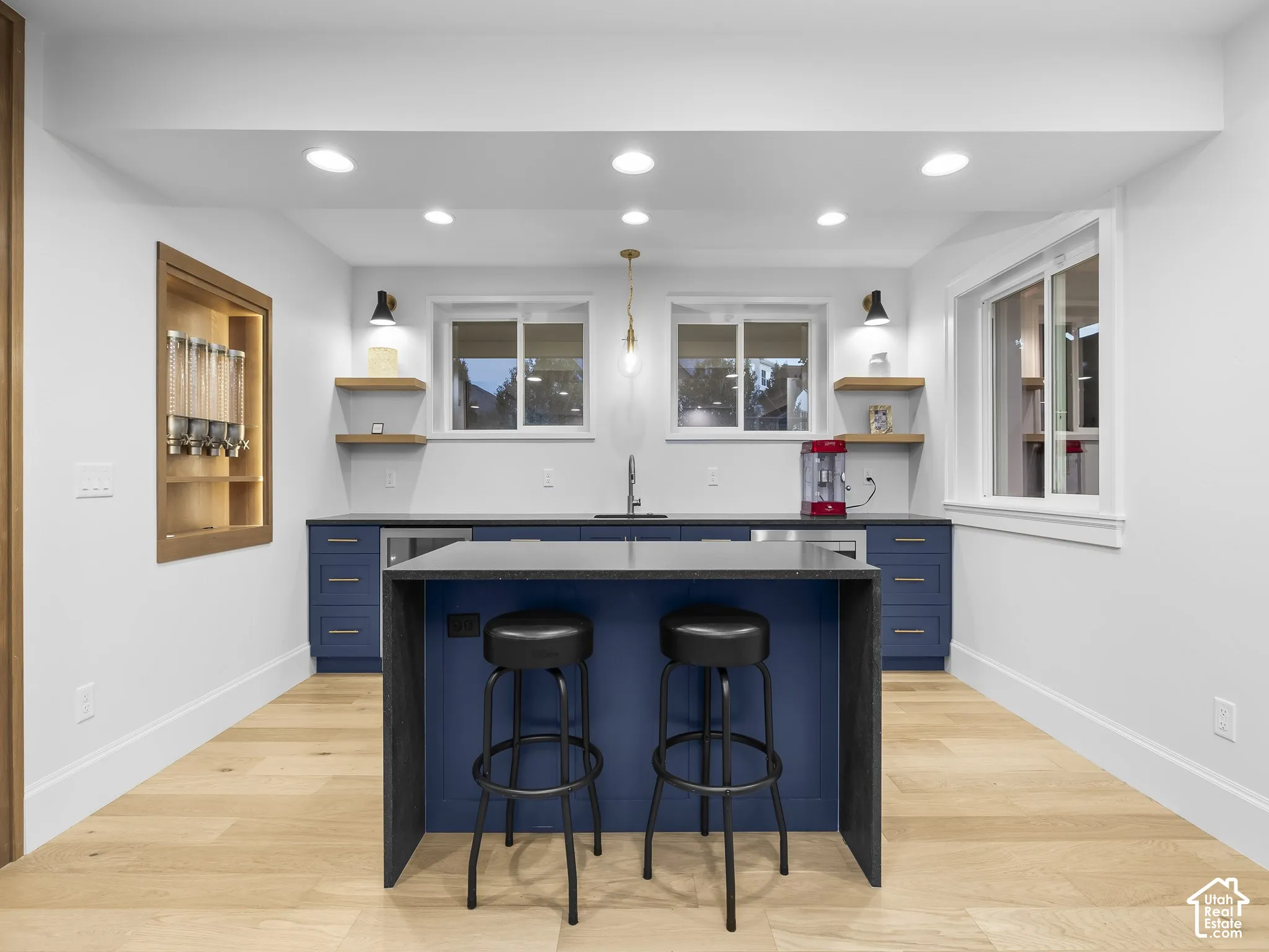 Contemporary kitchen with wood-finish flooring, recessed lighting, and a built-in beverage refrigerator