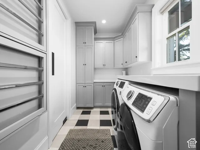 Laundry area featuring checkerboard-patterned floor tiles, window, built-in cabinetry, and countertop