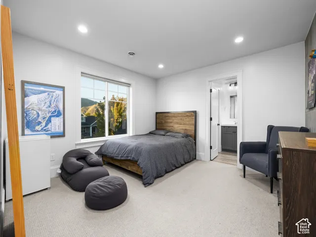 Recessed ceiling lighting, carpeted flooring, and a large window with natural scenery