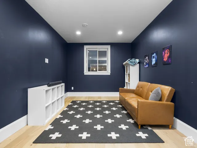 Recessed lighting, wood-finish flooring, white window trim, and baseboard molding