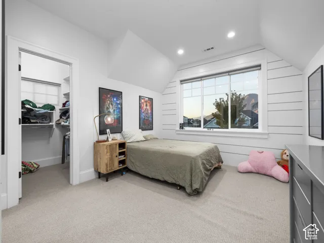 Recessed lighting, large window with integrated blinds, built-in closet shelving, shiplap accent wall, and neutral carpet